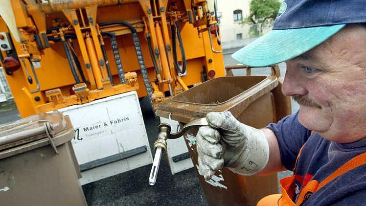 An dem Müllauto im Hintergrund sind zwei weiße Metalldetektoren zu sehen, die den Inhalt der Tonnen überprüfen. Befindet sich etwa Metall im Biomüll, schlägt der Detektor noch vor der Tonnenleerung Alarm.  Foto: Karl-Josef Hildenbrand, dpa