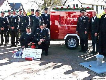 Zur Übergabe des Tragkraftspritzenanhängers war die Mannschaft der Feuerwehr Neida angetreten; rechts im Bild von außen: Stefan Schneyer, Pfarrer Karl-Heinz Hillermeier, Bürgermeister Bernd Höfer, Kreisbrandmeister Manfred Brückner; kniend die Kommandanten Dietmar Ehrlicher und Dittmar Resch.  Foto: Karin Günther