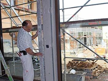 Michael Menninger arbeitet im Anbau der neuen gemeindlichen Kindertagesstätte in Poppenlauer. Bis zum Jahresende sollen die Arbeiten abgeschlossen werden. Foto: Heike Beudert