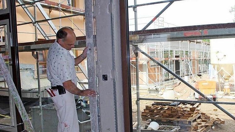 Michael Menninger arbeitet im Anbau der neuen gemeindlichen Kindertagesstätte in Poppenlauer. Bis zum Jahresende sollen die Arbeiten abgeschlossen werden. Foto: Heike Beudert