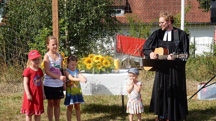 Pfarrer Michael Maul beim Gottesdienst im Grünen  mit seiner Tochter Frieda (2. v. r.) und ihren Freundinnen beim Singen eines Gottesdienstliedes. Foto: Reinhard Löwisch
