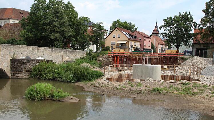 Der erste neue Pfeiler steht, das Widerlager ist noch eingerüstet. Die alte Aischbrücke (links) stört das alles wenig. Foto: Andreas Dorsch
