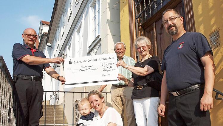 Die Familie Fehn um das Ehepaar Ulrike und Gerhard Fehn (Zweiter und Dritte von rechts) sowie deren Tochter Felicitas Fehn (kniend) mit dem Enkel Raphael bedankten sich bei allen beteiligten Feuerwehrleuten mit einer Spende von 1000 Euro, die Michael Haas (links) und Andreas Lehe stellvertretend für alle Kameraden entgegennahmen. Foto: Alfred Thieret