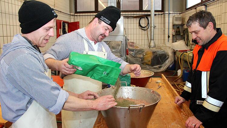 Die zwei Metzger (von li) Gerald Klotz und Harald Kraus rühren unter den kritischen Blicken des Kommandanten und Hilfsmetzgers Jürgen Hörrlein die Leberwurstfüllung an. Fotos: Johanna Blum