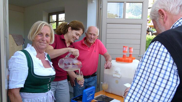 Annerose Ackermann (links) half Birgit Dietz und ihrem Ehemann Christian beim Einschenken des Federweißen.