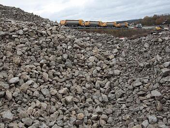 An der ICE-Baustelle bei Kersbach werden die Schotterberge zwischengelagert, bis die Lastwagen (Im Hintergrund) das Material zur neuen Trasse fahren. Foto: Josef Hofbauer