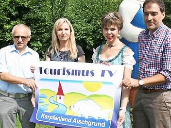 Noch druckfrisch ist das Plakat, das auf die TV-Produktion des Karpfenlands aufmerksam macht. Vestenbergs Bürgermeister Helmut Lottes, Sandra Hammer, Karpfenprinzessin Katrin Uano und Michael Raabe, Leiter der Greuther Teeläden, präsentieren es. Foto: Evi Seeger