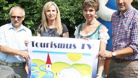Noch druckfrisch ist das Plakat, das auf die TV-Produktion des Karpfenlands aufmerksam macht. Vestenbergs Bürgermeister Helmut Lottes, Sandra Hammer, Karpfenprinzessin Katrin Uano und Michael Raabe, Leiter der Greuther Teeläden, präsentieren es. Foto: Evi Seeger