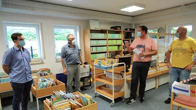 Nico Kauper, Günter Münch und Tim Scheppe (von links) lauschen Johannes Weiß (Zweiter von links) beim Besuch des Sozialausschusses in der Bücherei. Foto: Britta Schnake