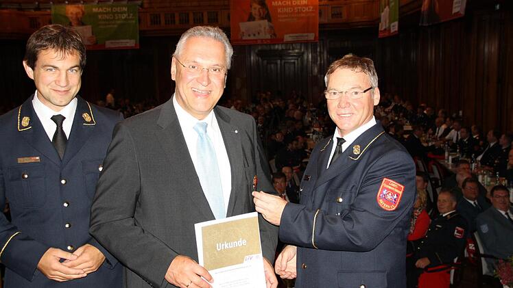 Weinzierl heftet dem Minister das Ehrenkreuz an.