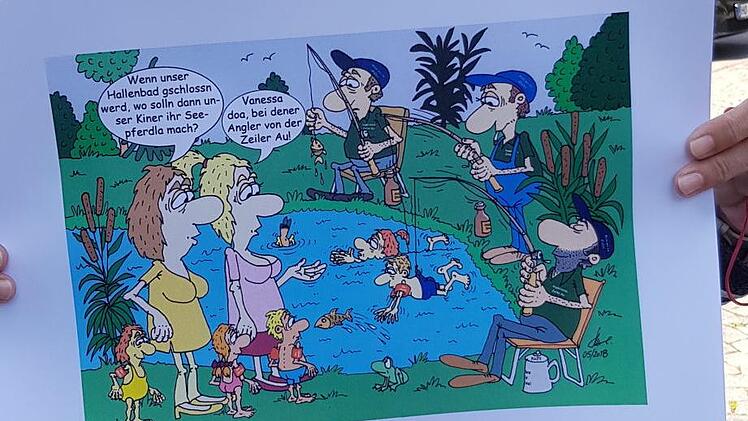Petra Hohenberger zeigt eine köstliche Karikatur von Klaus Strobel. Die nahm Petra Hohenberger mit in die Diskussion. Die Zeiler Kinder müssen wohl, wie zu sehen ist, bei Schließung des Zeiler Hallenbades bei den Anglern der "Zeiler Au" schwimmen lernen.