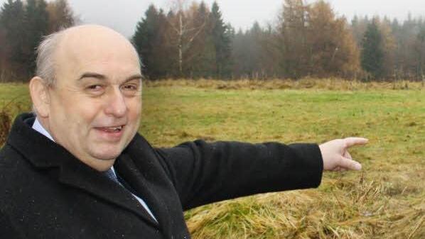 Der Wildfleckener Bürgermeister Alfred Schrenk zeigt auf die Wiese im ehemaligen Standortübungsplatz, auf der bald der neue Zeltplatz gebaut wird. Foto: Ralf Ruppert