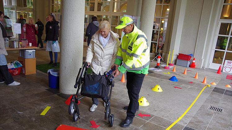 Ein Helfer gibt einer Frau Tipps auf dem Rollator-Parkcours. Foto: Klaus Werner