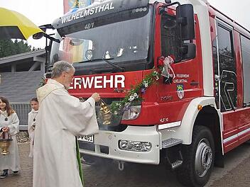 Pfarrer Erwin Lohneisen segnet das neue Feuerwehrfahrzeug.  Foto: Heike Schülein