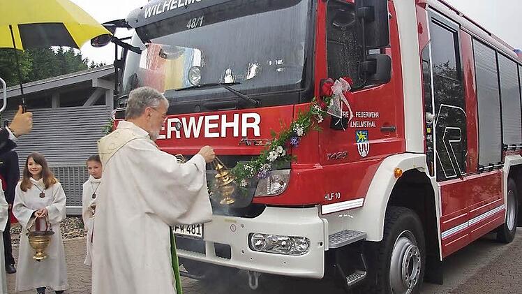 Pfarrer Erwin Lohneisen segnet das neue Feuerwehrfahrzeug.  Foto: Heike Schülein