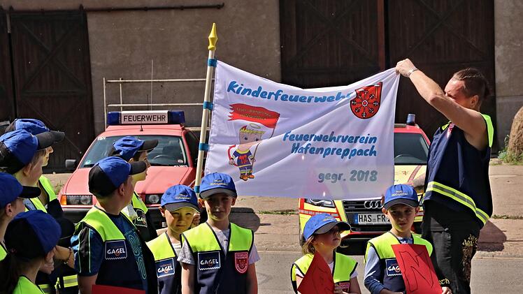 Kaum gegründet und schon eine Fahne: Oliver Schmitt, einer der Betreuer der "Feuer-(B)engelchen", zeigt mit einigen der Kinder die neue Fahne.Helmut Will