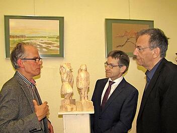 Diese Holzskulpturen sind im Kunstunterricht der neunten Jahrgangsstufe entstanden, ebenso die Bilder an der Wand. Von links: Kunsterzieher Peter Schmiedebach,  Schulleiter Hans-Joachim Döhner und Bürgermeister Thomas Nowak Foto: Martin Koch
