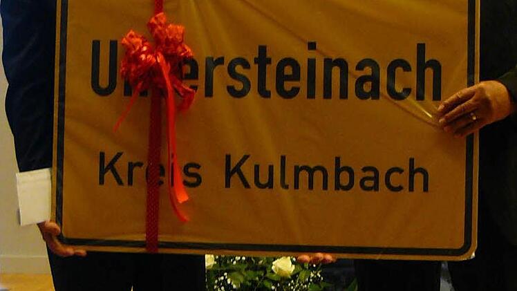 Übergabe eines Untersteinacher Ortsschildes von Bürgermeister Heinz Burges (rechts) an seinen Kollegen Krzystof Musial (links).