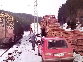 Edmund Wicklein steht am Bahnhof Förtschendorf zwischen seinem VW und einem geladenen Holzwaggon. Foto: Archiv Tobias Wicklein