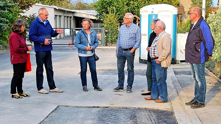Zu Beginn der wegen Beschlussunfähigkeit nicht durchgeführten Sitzung des  Rannunger Gemeinderates schauten sich die erschienenen Mitglieder in der  Straße am Hock, direkt am Rathaus um. Hier sollen im Zuge der Arbeiten auf  dem Schul- und Kirchhof der Gehweg und die Straße erneuert werden. Foto:  Dieter Britz