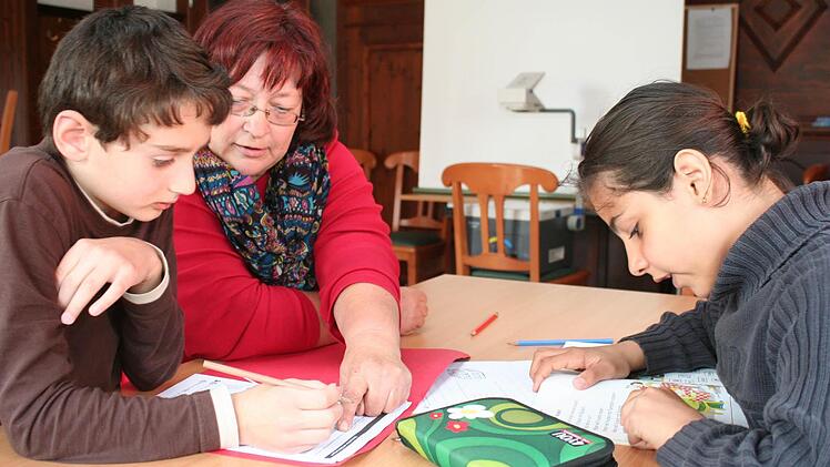 Die Wachenrotherin Gertraud Schuster (Mitte) betreut Aslan (l.) und Batoul bei ihren Hausaufgaben. Foto: Evi Seeger