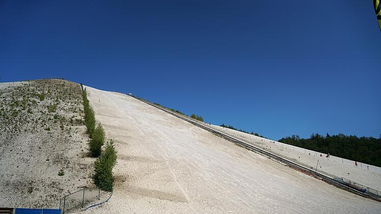 Monte Kaolino: Sandiger Ausflugstipp nahe Franken - für Skifahren im Sommer & mehr, Eine Aufnahme aus niedriger Perspektive der Skipiste in Monte Kaolino im Sommer A low angle view of the skiing trail in Monte Kaolino during summer  von Hel Fei/Wirestock