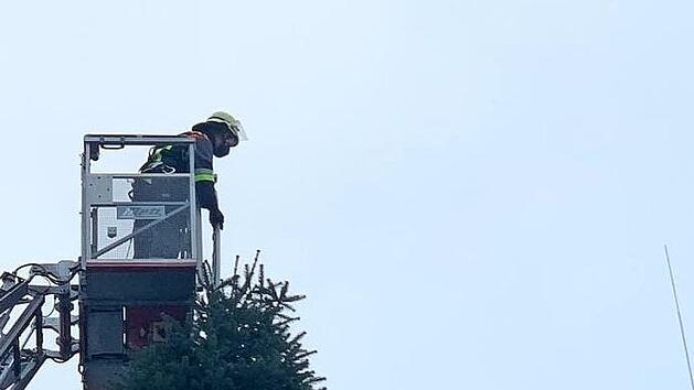 Mit Hilfe der Drehleiter gelangte der Weihnachtsbaum der Feuerwehr auf den Schlauchturm, wo er ein Zeichen der Hoffnung in den Baunachgrund sendet.  Foto: kb