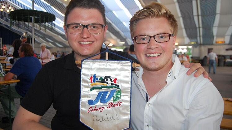 Christian Tanzmeier (links) und Maximilian Forkel präsentieren stolz den "JU"-Aufsteller mit einem Original-Autogramm von Angela Merkel.