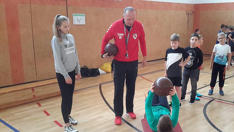 Genau beobachtet Klaus Sieß (Bildmitte) die Übung mit dem Medizinball. Rückwärts über eine schmale Bank zu robben und gleichzeitig das schwere Spielgerät in die Höhe zu halten, erwies sich besondere Herausforderung.  Foto: Rolf Pralle