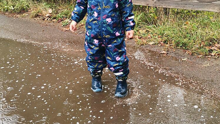 Wetter in Franken: Ein kleiner Junge steht in einer Regenpf&uuml;tze