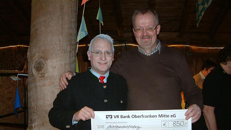 Initiator Martin Panzer (links)  übergab er den Erlös aus Eintrittsgeldern in Höhe von 850 Euro an Stadtpfarrer Thomas Teuchgräber (rechts). Der Regionaldekan  erklärte, dass die Spende der Pfarr-Caritas zugeführt werde. Hans Franz