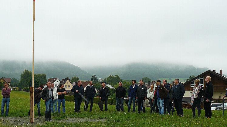 Ortstermin am Standort des Rewe-Marktes. An der Stange wird deutlich, wie hoch das Gebäude über dem Bodenniveau wird.