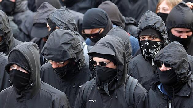 Eine Gruppe mit teils Vermummten zieht vor dem Wohnhaus eines Polizisten in Niedersachsen auf. Dort versuchen etwa 60 Menschen, die Familie einzuschüchtern. Politiker verurteilen den Vorfall scharf. Symbolbild: Michael Kappeler/dpa