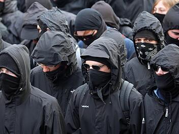 Eine Gruppe mit teils Vermummten zieht vor dem Wohnhaus eines Polizisten in Niedersachsen auf. Dort versuchen etwa 60 Menschen, die Familie einzusch&uuml;chtern. Politiker verurteilen den Vorfall scharf. Symbolbild: Michael Kappeler/dpa