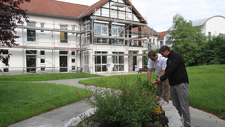 Im Zuge des Umbaus ist auch das Gelände rund um das Seniorenheim neu gestaltet worden - mit Wegen und mit Hochbeeten, die für Rollstuhlfahrer und andere zugänglich sind, freuen sich Pflegedienstleiter Stefan Tippner und Maximilian Türk vom BRK. Foto: Sonja Adam