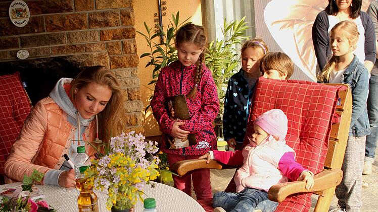 Kinder des Ortes hießen den prominenten Gast mit Blumen willkommen und ließen sich Autogramme schreiben.  Foto: Günther Geiling