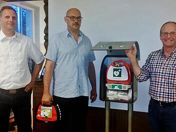 ZTM-Projektleiter Thomas Schreiner (von links) sowie die beiden Stadträte Klaus Zehe und Walter Schuhmann (Freie Wähler) in Albertshausen bei der Präsentation des Defibrillators. Foto: Sigismund von Dobschütz