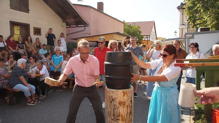 Bürgermeister Wolfgang Desel sticht das erste Fass Festbier an und Nicole Düsel assistiert ihm.