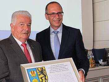 Das Wappen des Landkreises in dieser Form hat er noch nicht, der vielfach ausgezeichnete Kreisrat Winfried Weinbeer (l.). Landrat Meißner überreichte es zum besonderen Jahrestag.  Foto: R. Popp