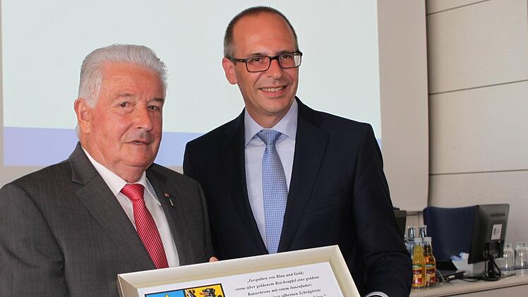 Das Wappen des Landkreises in dieser Form hat er noch nicht, der vielfach ausgezeichnete Kreisrat Winfried Weinbeer (l.). Landrat Meißner überreichte es zum besonderen Jahrestag.  Foto: R. Popp