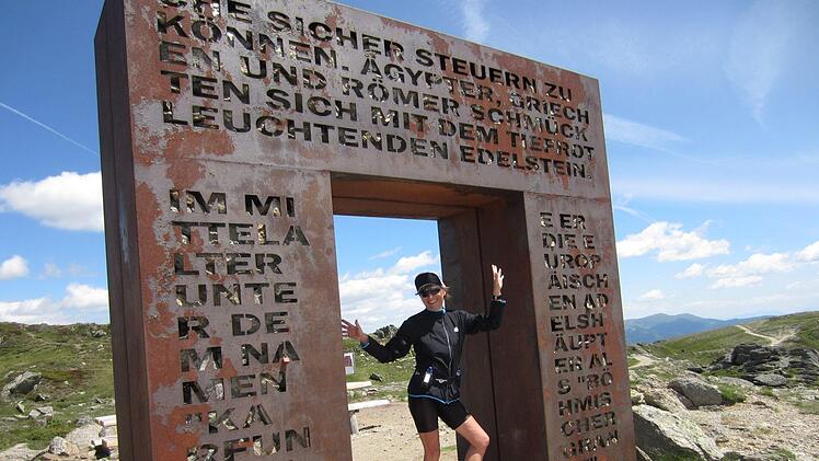 Brigitte Bärnreuther hat den Anstieg zum Granattor mit ihren Kollegen gemeistert und posiert vor einem Denkmal.