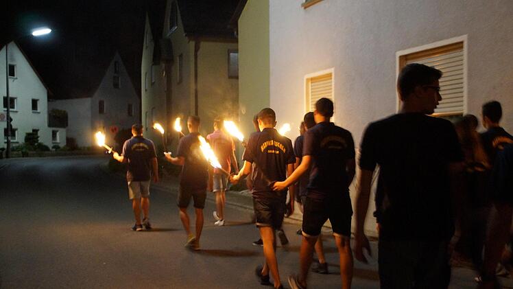 Mit Fackeln zogen die Kerwasburchen und -madla singend zum Baumloch.Kirchehrenbacher Kerwasburschen