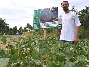 Mit einem Schild in seinem Soja-Acker weist Landwirt Andreas Gerner an der Straße von Birnfeld nach Bundorf auf sein Patenschaftsangebot zugunsten des Schutzes des Regenwaldes hin. Foto: Silvia Eidel