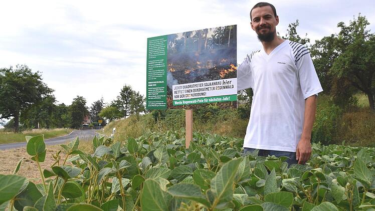 Mit einem Schild in seinem Soja-Acker weist Landwirt Andreas Gerner an der Straße von Birnfeld nach Bundorf auf sein Patenschaftsangebot zugunsten des Schutzes des Regenwaldes hin. Foto: Silvia Eidel