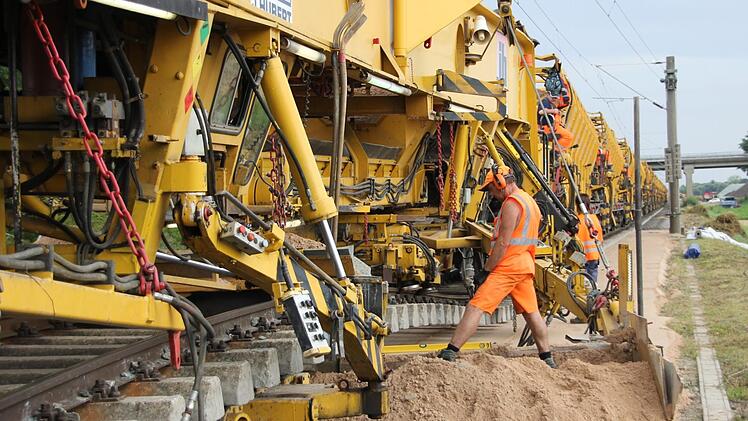 Die Sandeinbringungs-, Verteil- und Verdichtmaschine im Einsatz: Das etwa 400 Meter lange Monstrum baut den Sand und den Schotter ein.