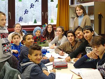 Anna Kramlich (hinten, stehend) unterrichtet Flüchtlingskinder in der Übergangsklasse. Wenn die Deutschkenntnisse von Ibrahim, Raed, Spase, Emy, Elisabeth, Ayat, Satiria, Ipek, Fadi, Abdulah, Amar und Mohamed besser sind, können die Kinder in die DAZ-Klasse und dann in ihren Regelklassen bleiben.  Foto: Stephanie Elm