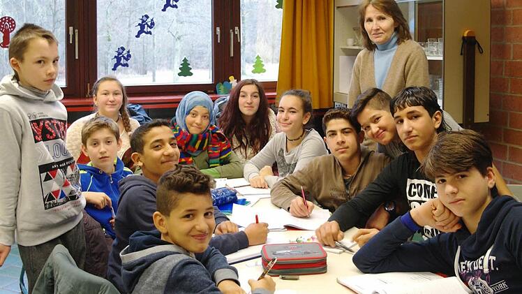 Anna Kramlich (hinten, stehend) unterrichtet Flüchtlingskinder in der Übergangsklasse. Wenn die Deutschkenntnisse von Ibrahim, Raed, Spase, Emy, Elisabeth, Ayat, Satiria, Ipek, Fadi, Abdulah, Amar und Mohamed besser sind, können die Kinder in die DAZ-Klasse und dann in ihren Regelklassen bleiben.  Foto: Stephanie Elm