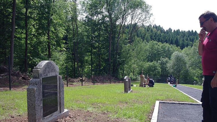 Heinrich Arnold vom Staatlichen Bauamt Schweinfurt (Tiefbau) vor einem der sanierten Grabsteine. Foto: Stephanie Elm