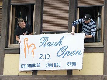 Alle sollen es sehen: Steffen Gruber (links) und Michael Bauer hängen das Schild zu ihrem Konzertabend "Rauh open" an die Fassade der Gaststätte "Goldenes Eichhorn". Am 2. Oktober sollen hier rund 300 Gäste kommen. Fotos: Thomas Heuchling