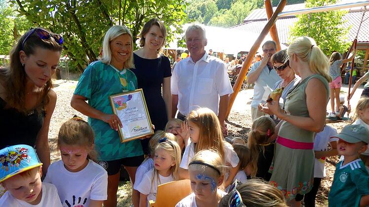 Bürgermeister Werner Diersch, MdB Emmi Zeulner und KiTa-Leiterin Jacqueline  Ramming (hinten, von rechts) an der Schminkstation, die beim Sommerfest  stark nachgefragt wurde. Foto: Dieter Hübner